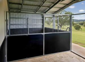 Horse stable with open countryside view.