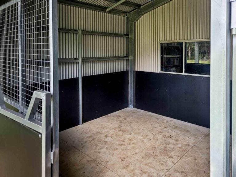 Empty animal enclosure with metal door and window.