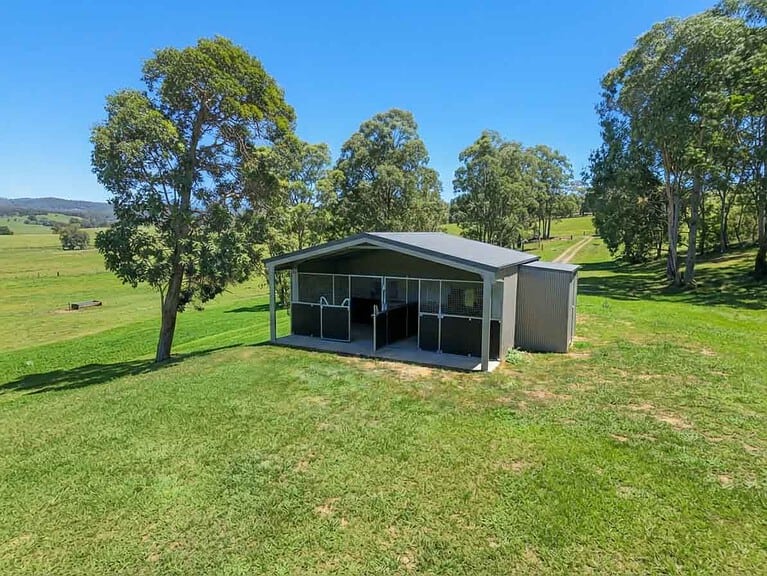 Steel two-bay horse stable with three-panel yoke gates and reinforced ply lining inside a converted rural shed