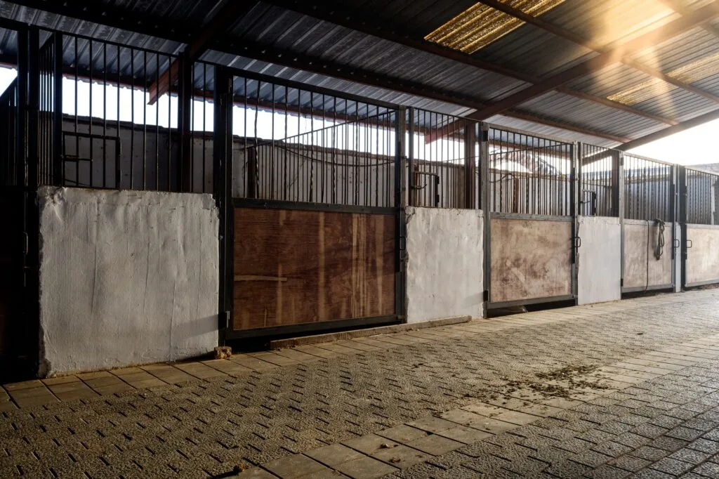 Empty horse stables in a large open shed