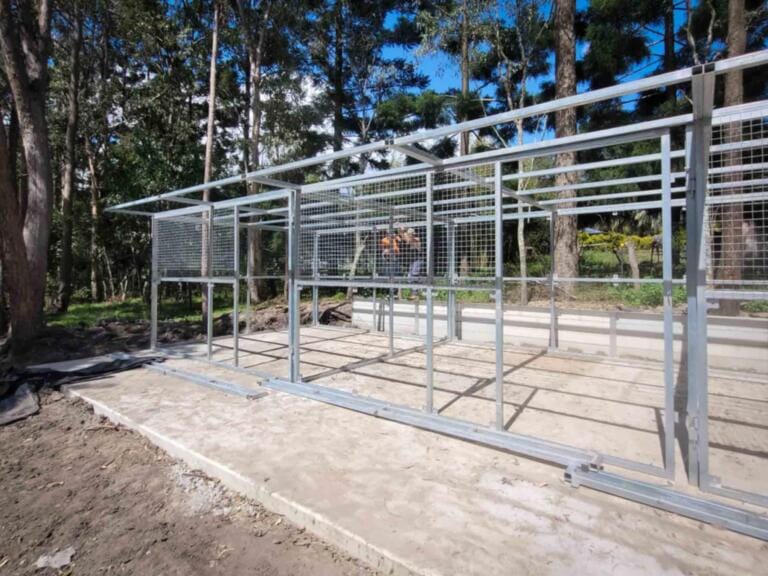 Partially assembled horse stable frame with upright steel posts and roof supports in place – illustrates strength and precision fit.