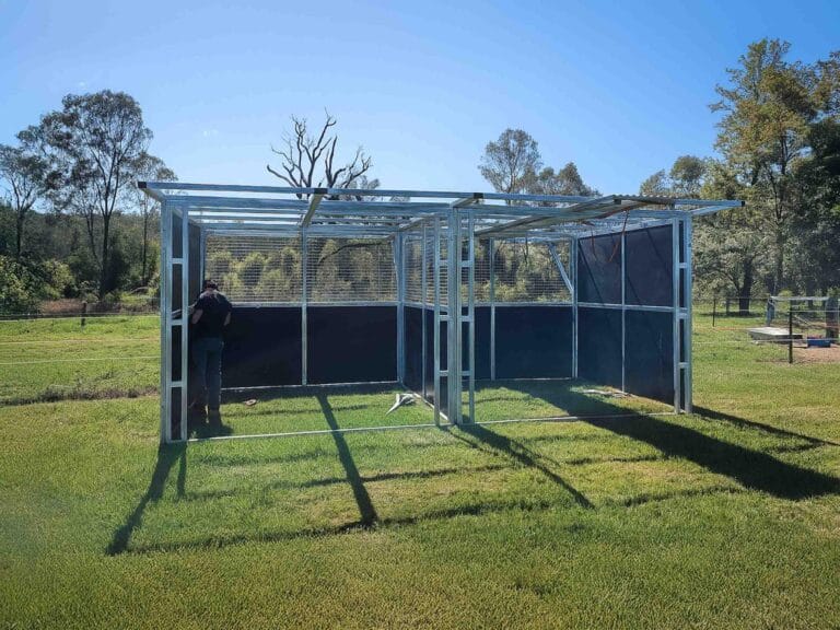 Person assembling outdoor steel structure in a field.