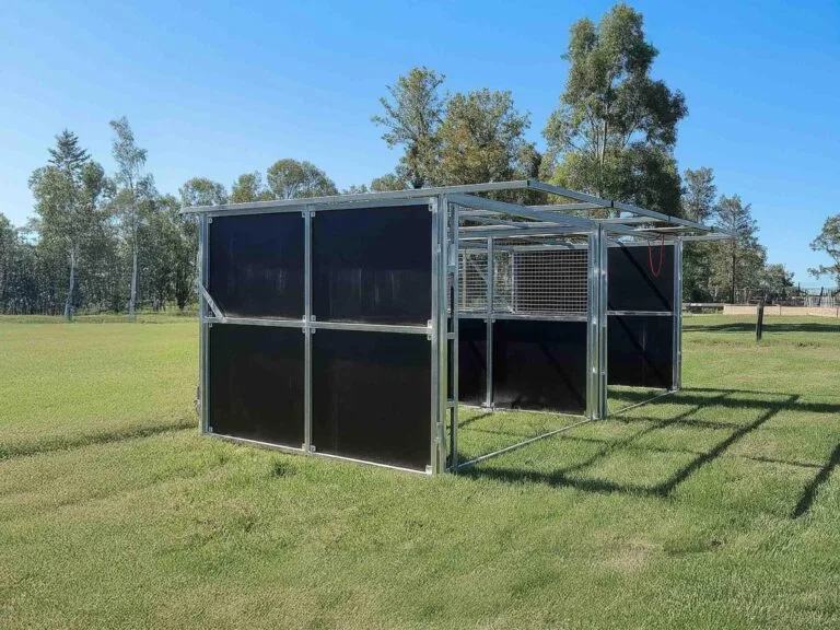 Metal enclosure on grassy field under clear sky.