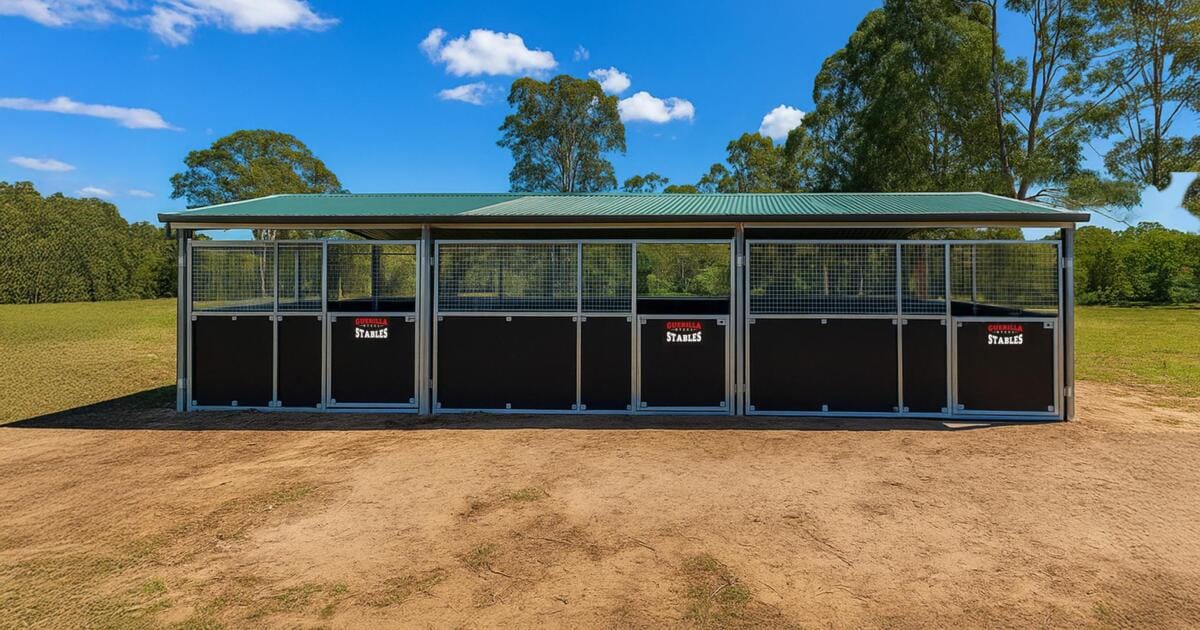 Modern horse stables in scenic countryside setting.