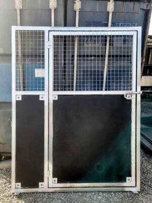 Metal security gate near shipping container.