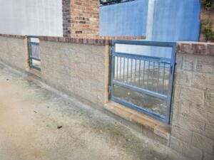Brick wall with metal gate in urban setting.