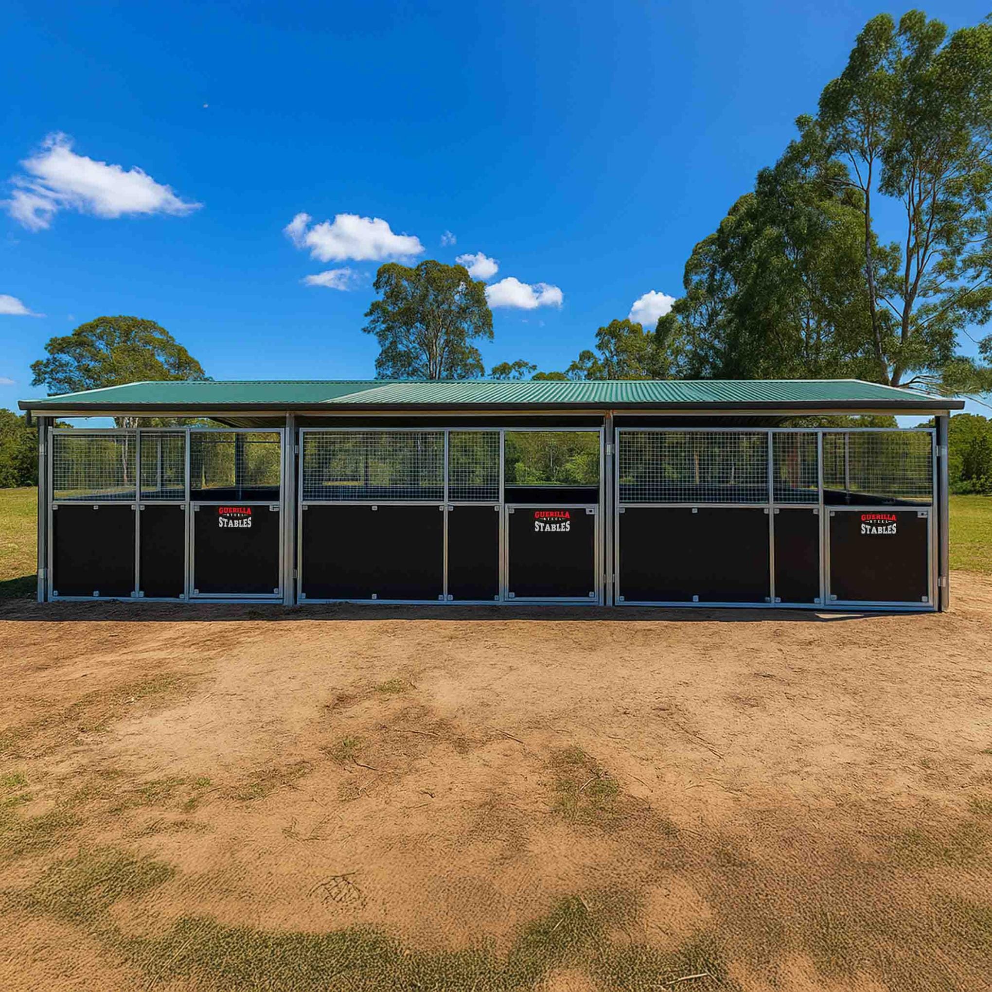Outdoor stables under blue sky with gumtrees.