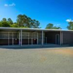 Large barn with stables near lush trees
