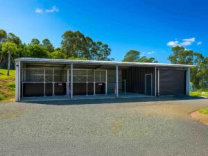 Large barn with stables near lush trees