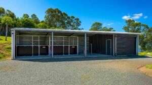 Rural metal barn with roll-up door and stables.