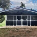 Outdoor horse stable with fenced enclosures.