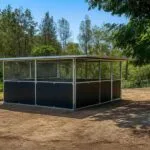 Outdoor animal enclosure under trees in bushland setting.