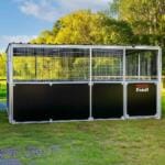 Outdoor horse stable on green field.