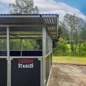 Modern steel horse stables in rural setting.