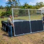 Men assembling a trailer gate on farm.