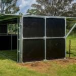 Modern horse shelter in grassy paddock