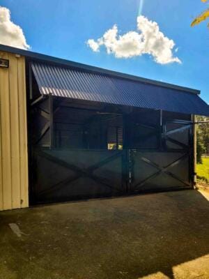 black steel stable breezeway side view with wide access doors and airflow design