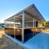 Modern outdoor horse shelter with metal roof.