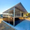 Modern outdoor horse shelter with metal roof.