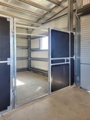 Sturdy steel animal enclosure with open door.