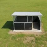 Top-down view of modular horse stable placed on concrete slab in grass paddock