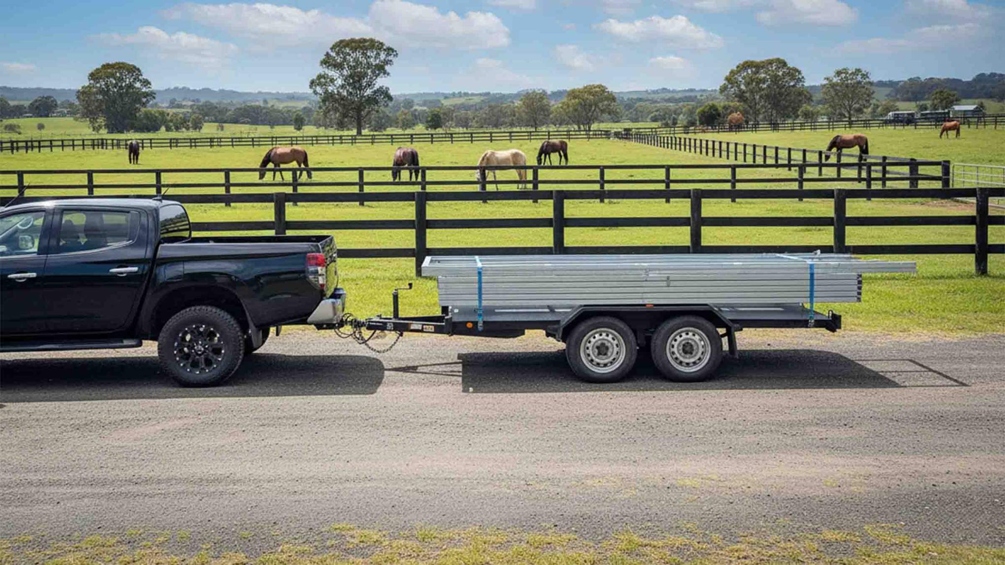 Ute with trailer near horse paddock.