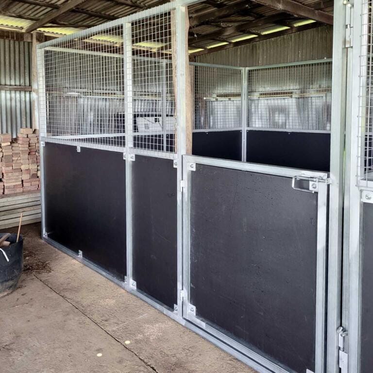 Metal horse stable interior with wooden panels.