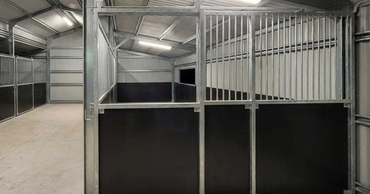 Closed vertical bar sliding gate on custom indoor stable, aligned with welded frame and ply base panels.