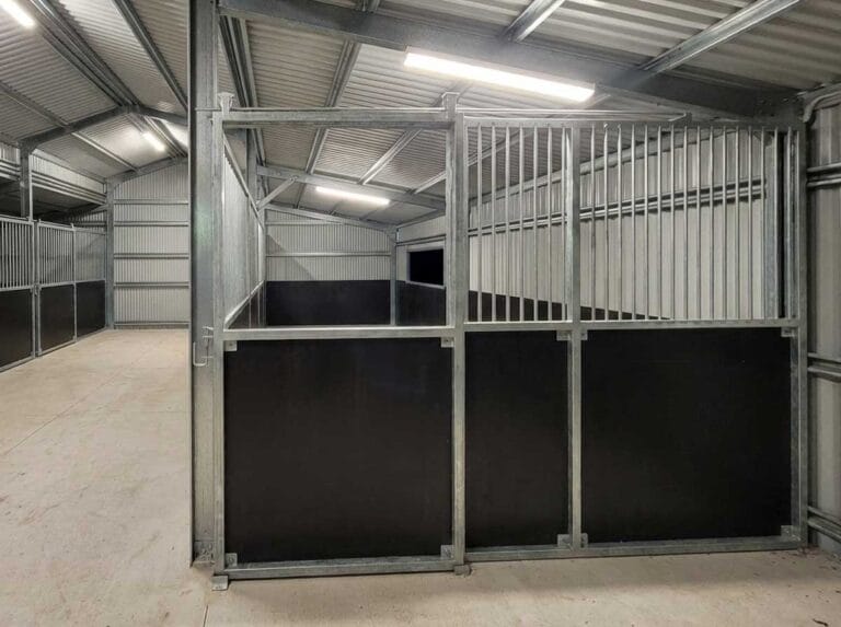 Closed vertical bar sliding gate on custom indoor stable, aligned with welded frame and ply base panels.