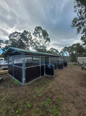Side profile of triple bay stable retrofit under afternoon light, showcasing roofline extension and corrosion-resistant finish built for Queensland conditions.