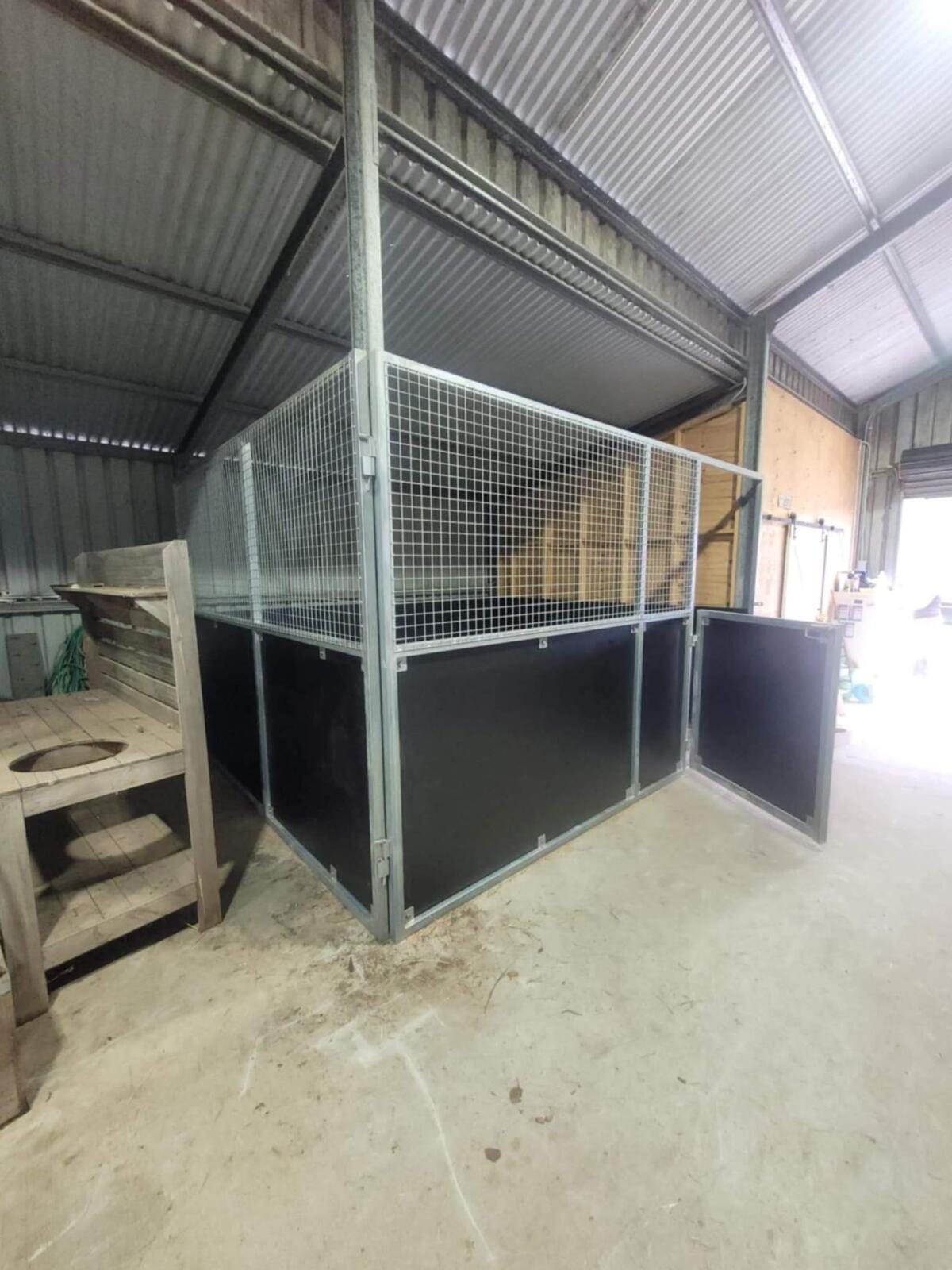 Indoor animal pen with metal fencing in shed