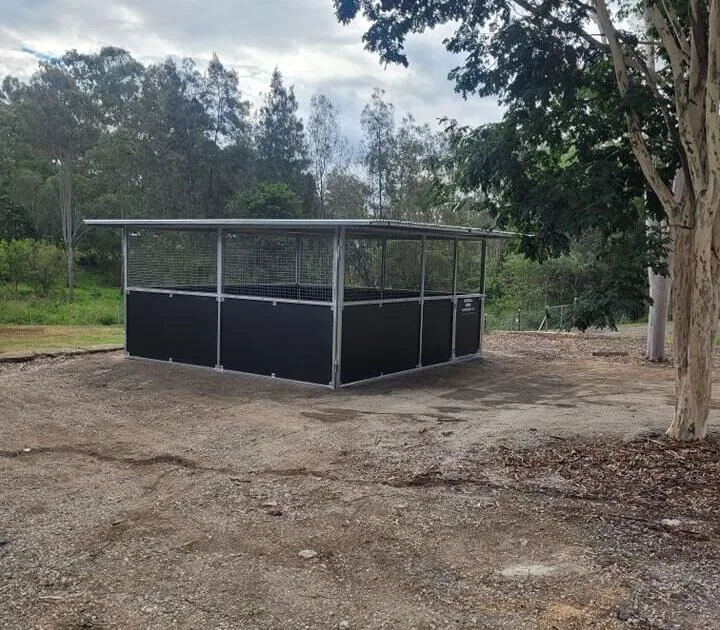 Single-bay horse stable on compacted ground with welded steel frame and mesh-top ventilation.