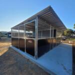 Side view of adjoining horse stables showing welded frames and ventilated mesh-top panels