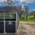 Standalone welded steel horse stable installed on compacted ground in Samford Valley featuring mesh airflow panels and large weather-protective roof.