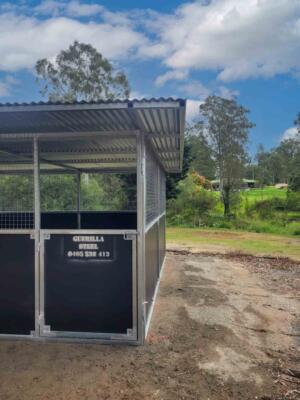 Standalone welded steel horse stable installed on compacted ground in Samford Valley featuring mesh airflow panels and large weather-protective roof.