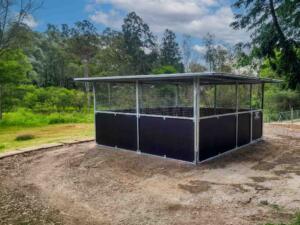 Side view Guerilla Steel horse stable in Samford Valley showing extended roof span, mesh ventilation panels and welded steel frame.