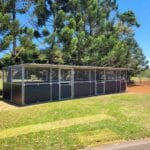 3 bay modular steel horse stable with mesh upper panels and ply kickboards installed in paddock