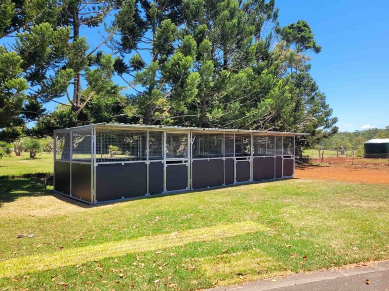 3 bay modular steel horse stable with mesh upper panels and ply kickboards installed in paddock