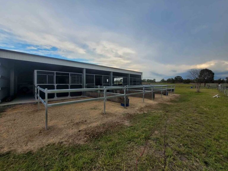 horse day yards with heavy duty two rail steel fencing attached to stables