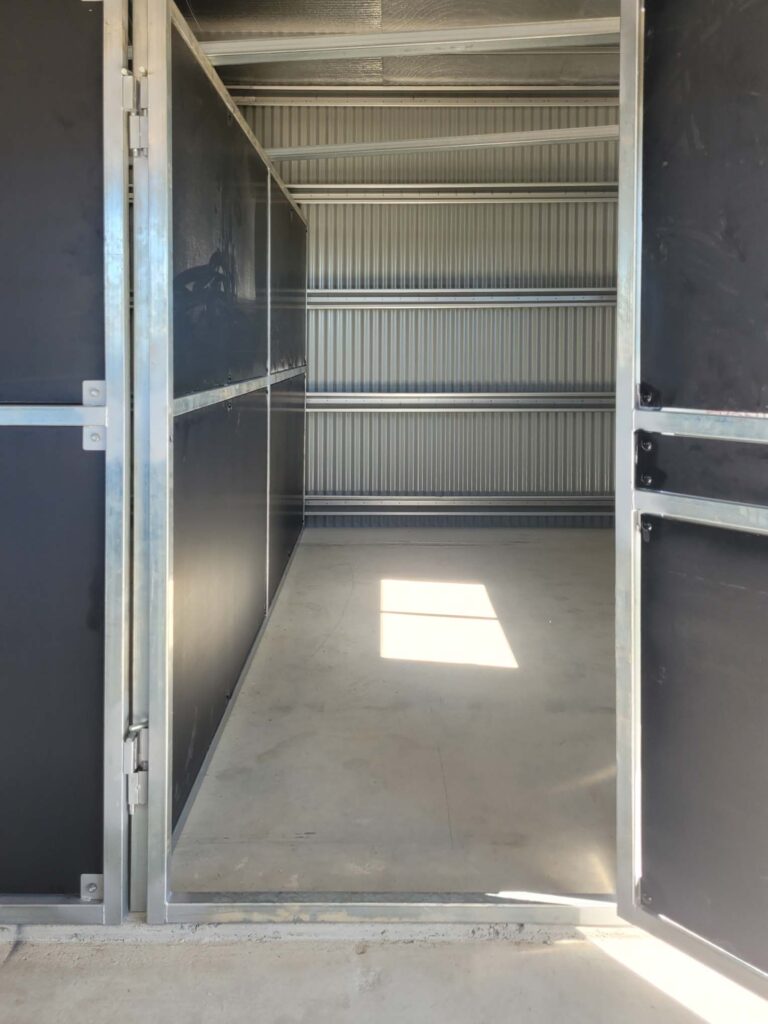 enclosed horse stable bay interior with overhead steel rails and framed structure