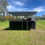 Single bay steel horse stable with roof and mesh panels in a paddock with a horse inside