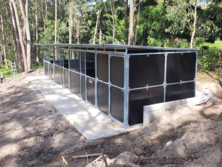 side view of a 3 stall steel modular horse stable with pitched roof and airflow mesh panels