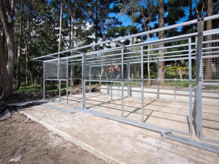 galvanised steel frame for a 3 bay horse stable under construction on concrete slab in rural bush setting
