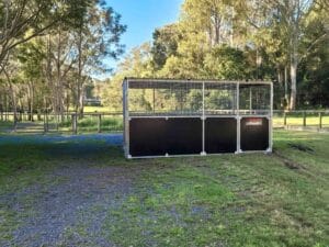 Custom steel dog pen with mesh upper panels and half height swing gate