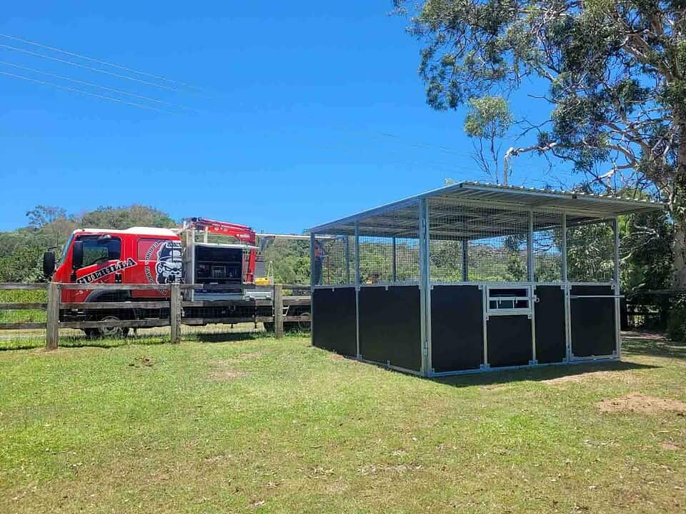 Practical steel stable bay at Samford showing working layout with front gate feed hatch and tie-up rail