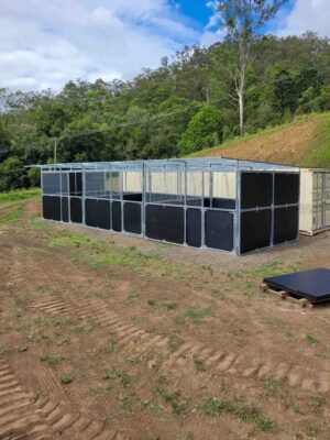 modular steel horse stable system with custom roof extension to container storage in progress