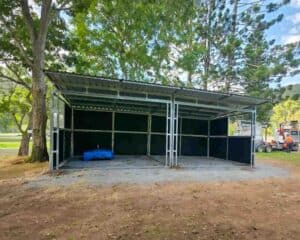 Long horse shelter with open bays and pitched roof on a timber site